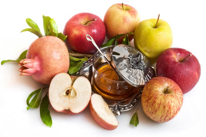 Apples, Pomegranate, and Honey on White Background