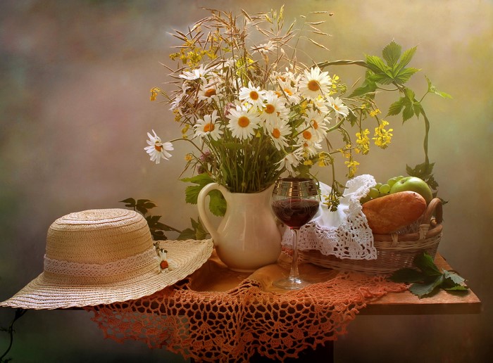 Still life with daisies, wine, bread, and a hat