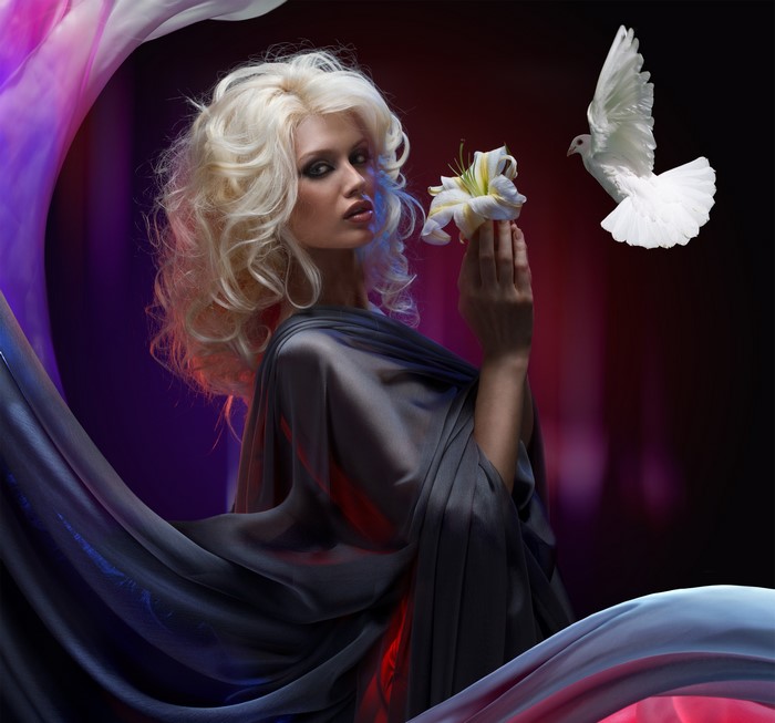 Blonde woman holding a lily with a dove flying