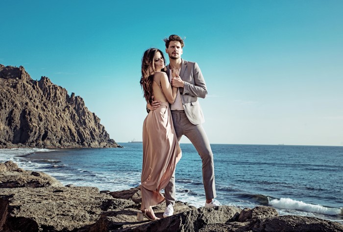 Couple embracing on a rocky coast