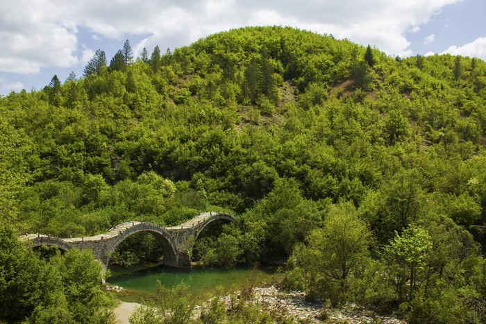 Stone arched bridge over a river in Zagorochoria, Greece