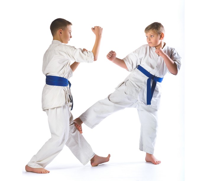Two boys in karate uniforms practicing martial arts