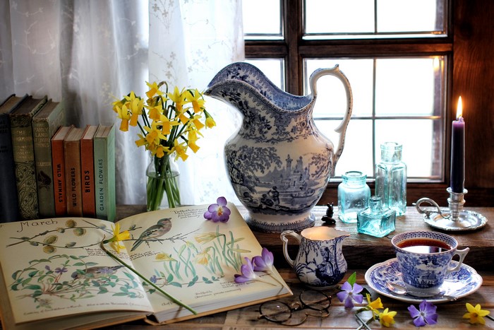 Still life with daffodils, books, and tea by the window