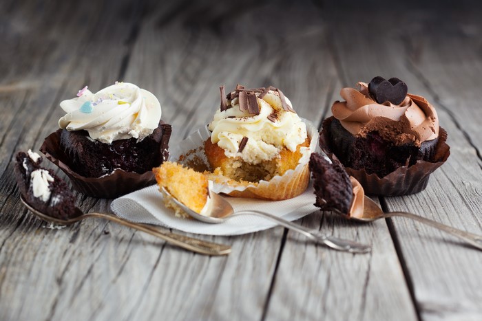 Cupcakes with spoons on wooden table