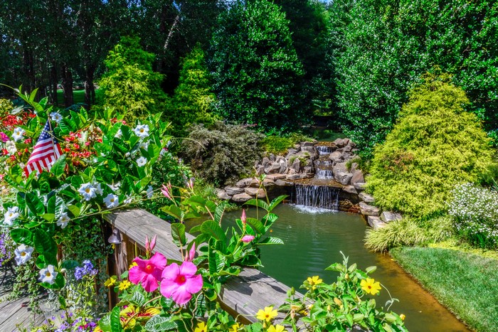 Gibbs Gardens waterfall with American flag and flowers