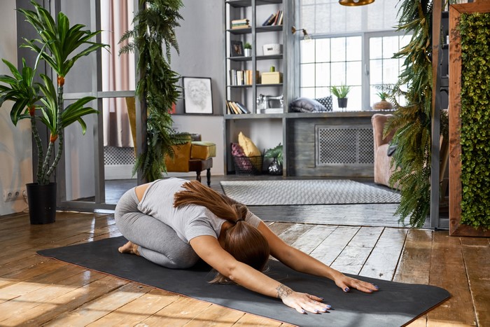 Woman doing yoga on a mat in a room