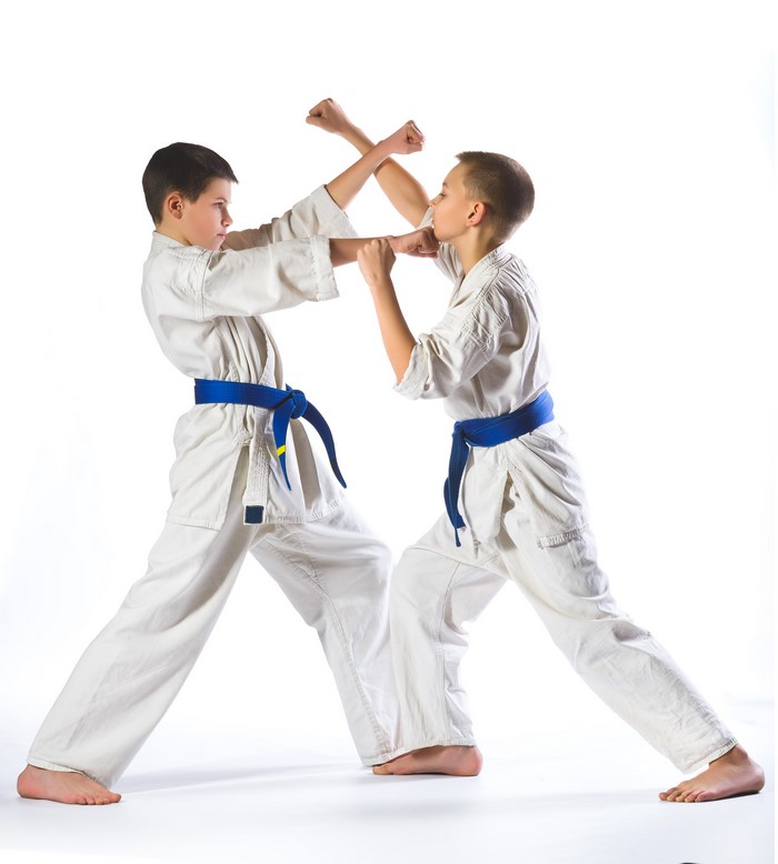 Two boys practicing karate in white uniforms