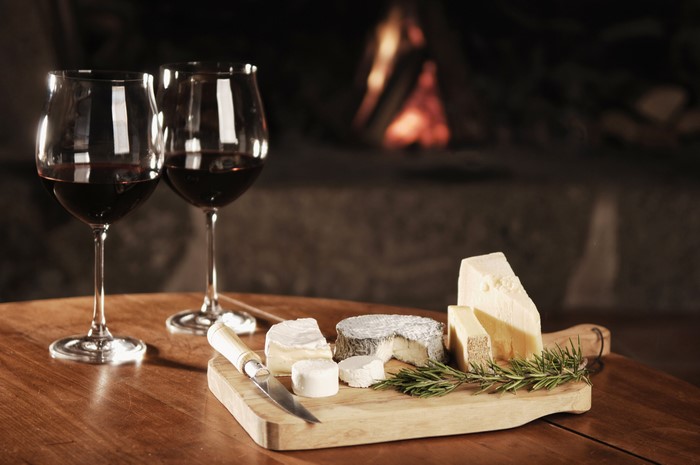 Cheese and red wine by a fireplace