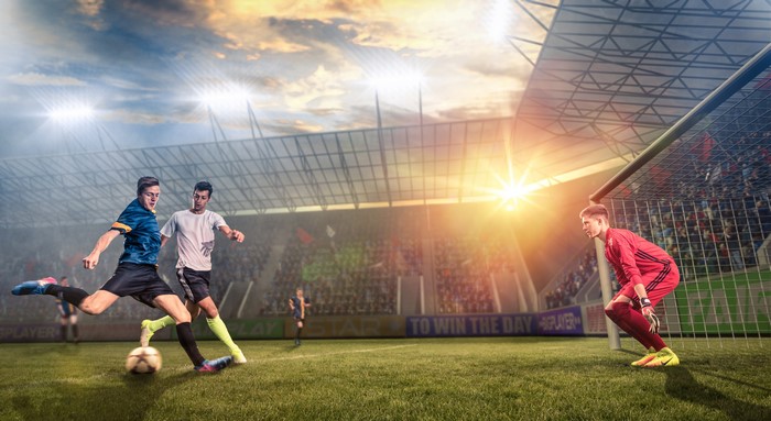 Football players and goalkeeper in stadium