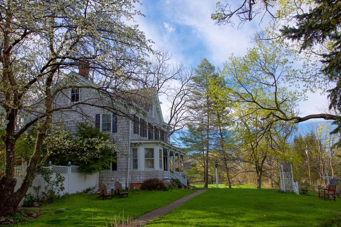 Victorian house with flowering trees and lawn