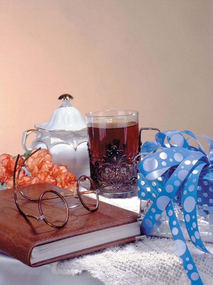 Still life with tea, book, glasses, and gift