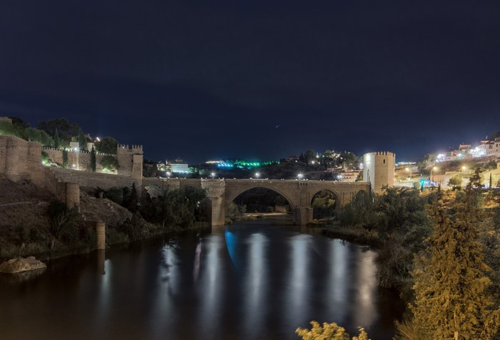 Puente de San Martín bridge over the Tagus River at night in Toledo, Spain