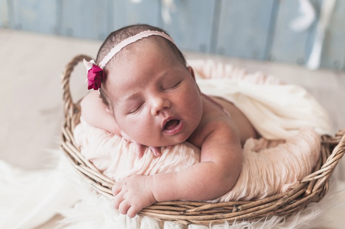 Newborn baby girl sleeping in a basket