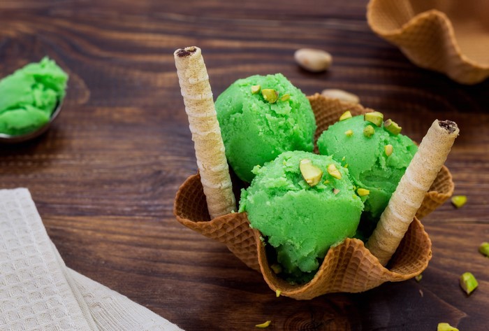 Pistachio ice cream in a waffle bowl with wafer rolls