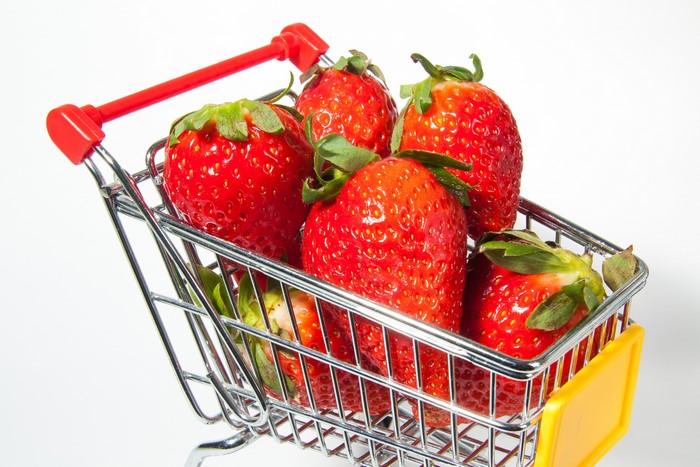 Strawberries in a shopping cart on a white background