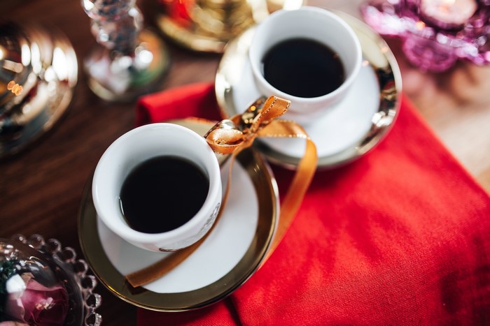 Two cups of coffee with golden ribbons