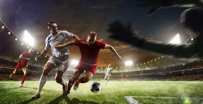 Men playing soccer on a stadium lawn