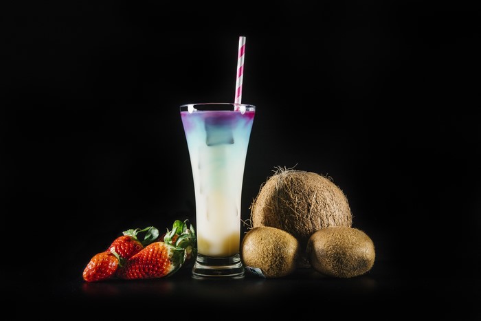 Cocktail with Strawberries, Kiwis, and Coconuts on Black Background