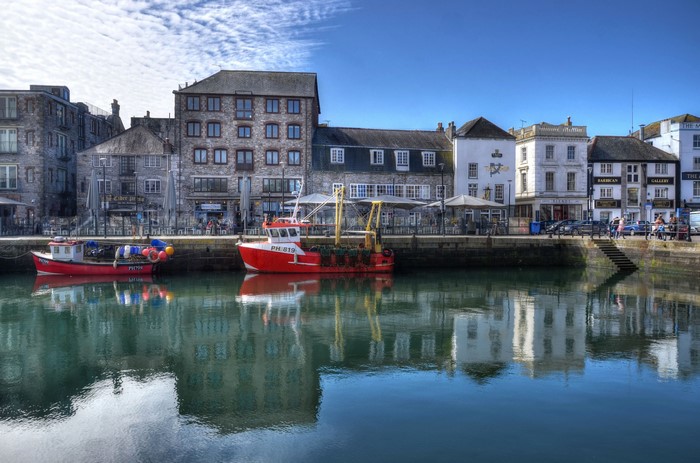 Boats docked in a harbor with buildings in Plymouth, England