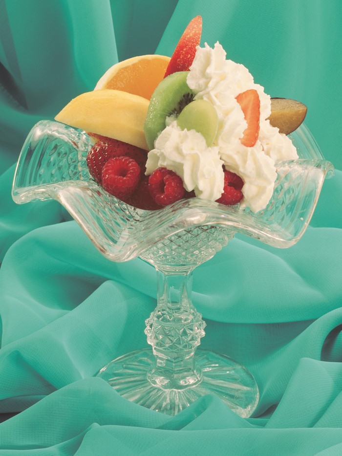 Fruit salad with whipped cream in a glass bowl