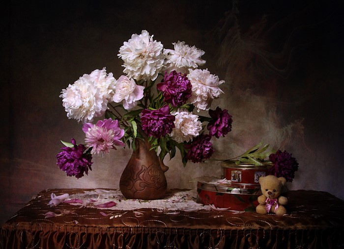 Still-life of peonies in a vase with a teddy bear and boxes