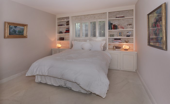 Bedroom with built-in bookshelves and artwork