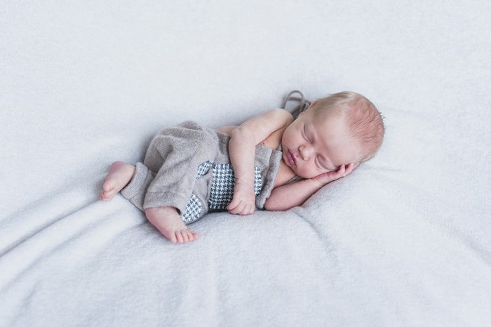 Newborn baby sleeping on a white blanket
