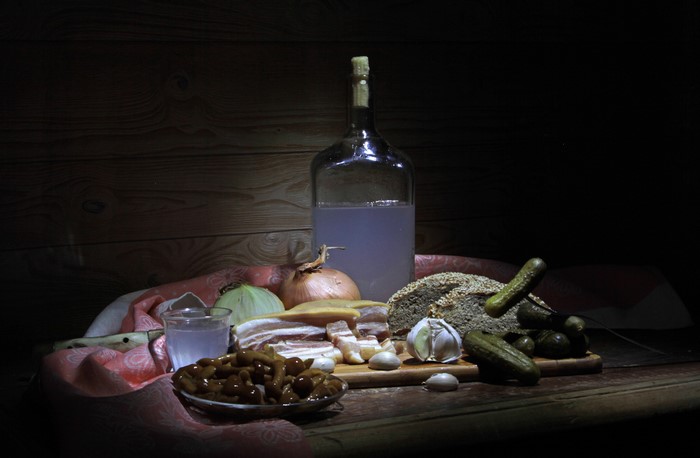 Still life with vodka, salo, bread, and pickles