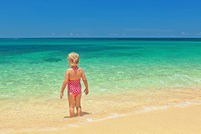 Little girl in swimsuit at the beach