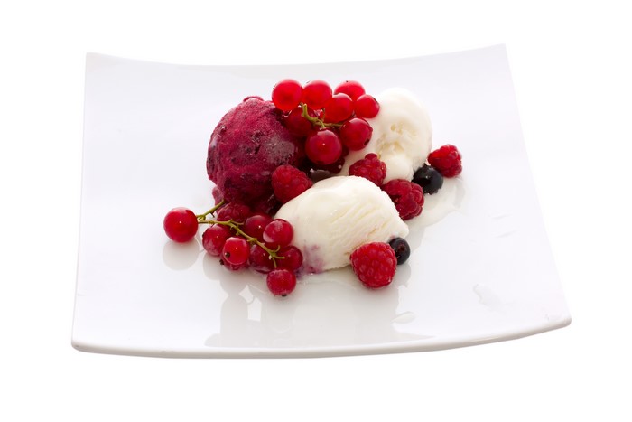 Ice cream with berries on a white plate