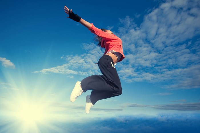 Woman jumping in the sky with sun