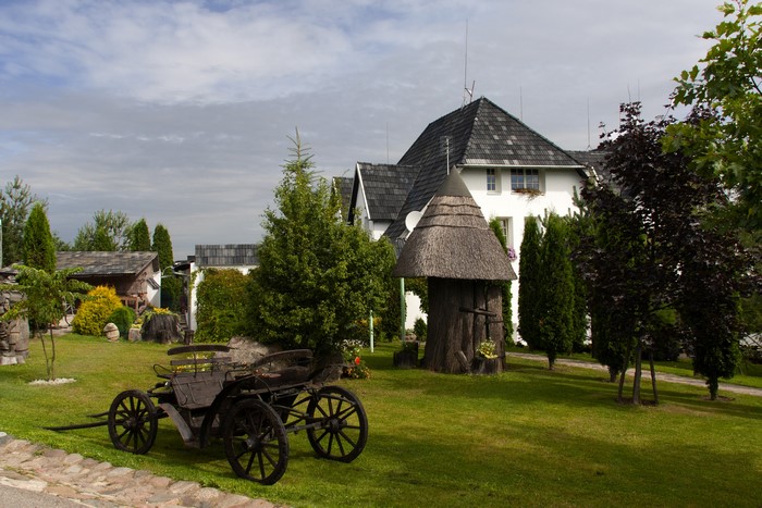 Old horse-drawn carriage in front of a white house in Kretinga, Lithuania