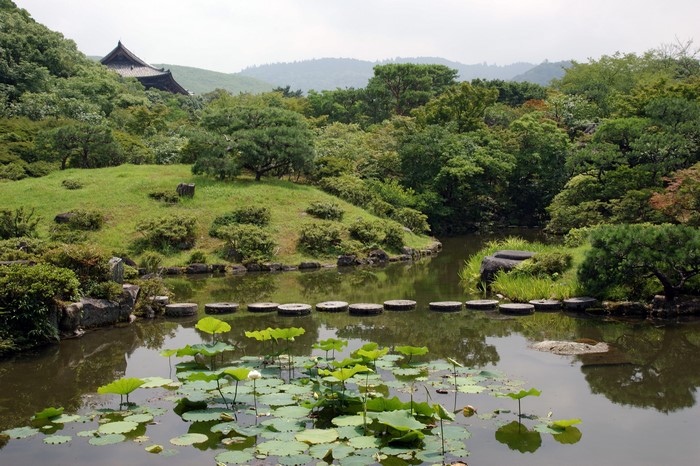 Japanese garden with pond, stepping stones, and temple building