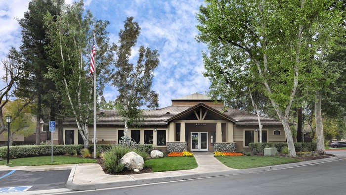 Apartment building entrance with American flag and trees