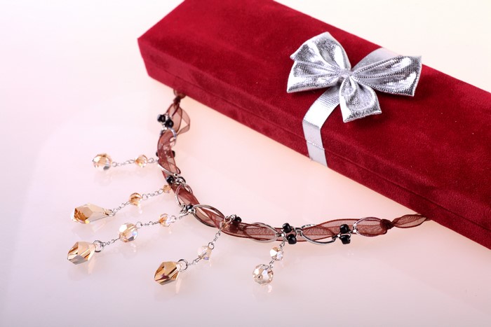 Red gift box with silver bow and necklace