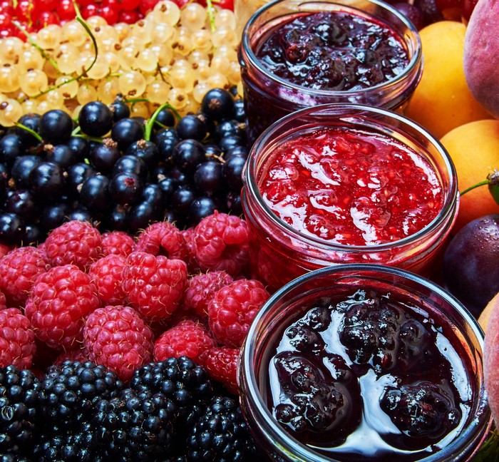 Jars of berry jam with fresh berries