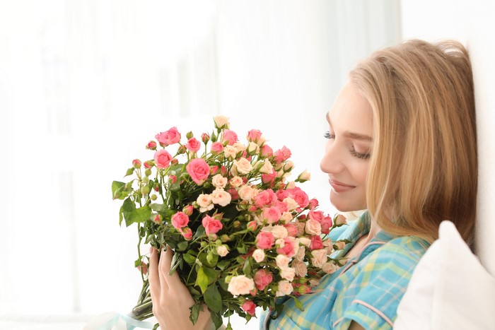 Blonde girl holding a bouquet of roses