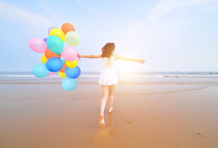 Girl with Balloons on the Beach