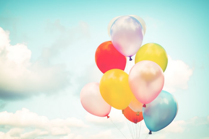 A bunch of colorful balloons floating in the sky