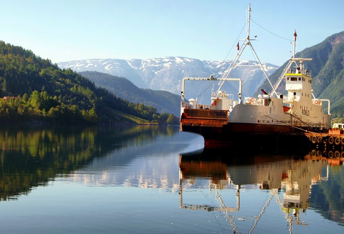Ship docked in a Norwegian fjord with mountains