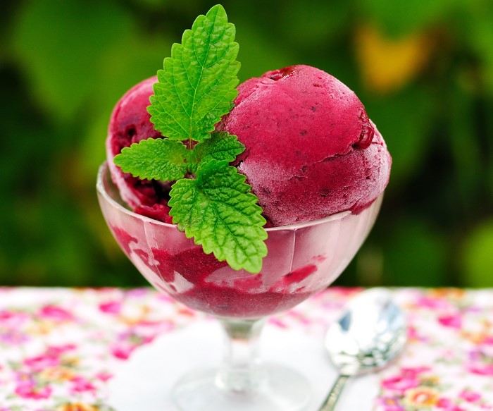 Berry ice cream in a glass dish with mint