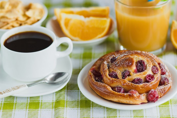 Breakfast with coffee, pastry, orange juice, and fruit