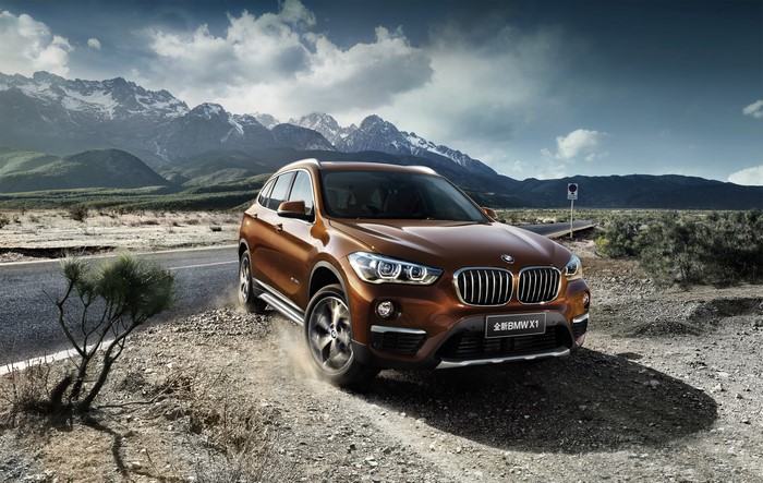 Orange BMW X1 xDrive25Li xLine on a dirt road