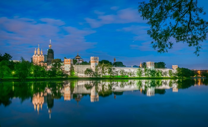 Novodevichy Monastery on the bank of a river at dusk