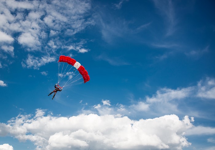 Parachuting with a red and white parachute