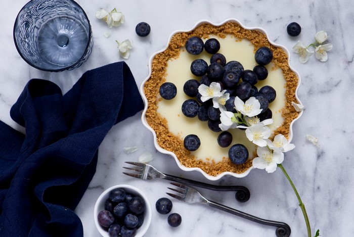 Blueberry Tart with White Flowers and Blue Glass