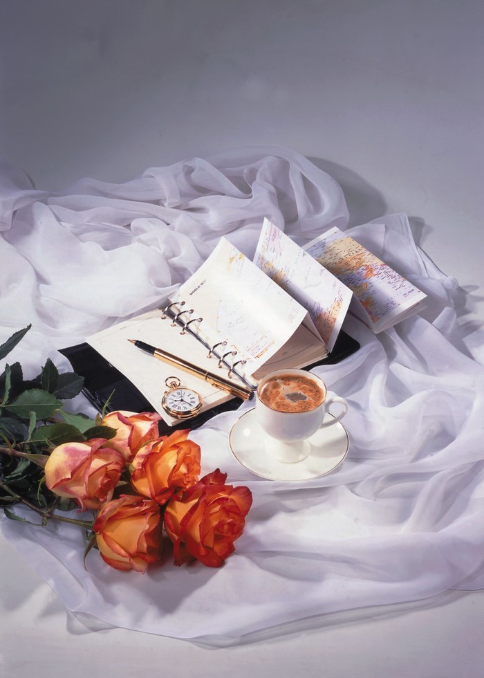 Still-life with roses, coffee, and notepad
