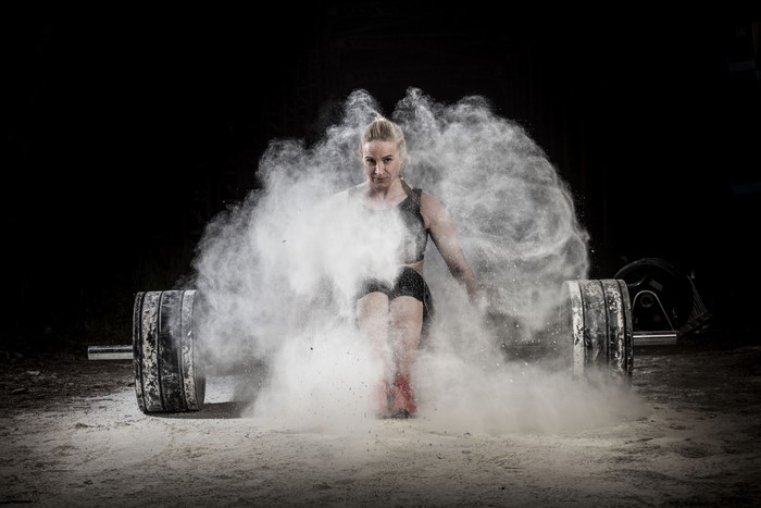 Woman with barbell and chalk cloud