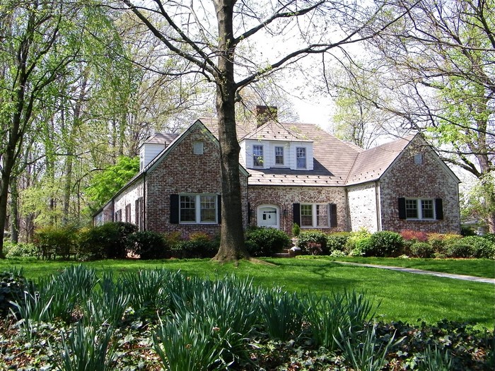 Brick house with a large lawn and trees