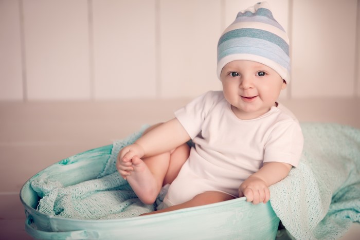 Baby in a striped hat and white onesie